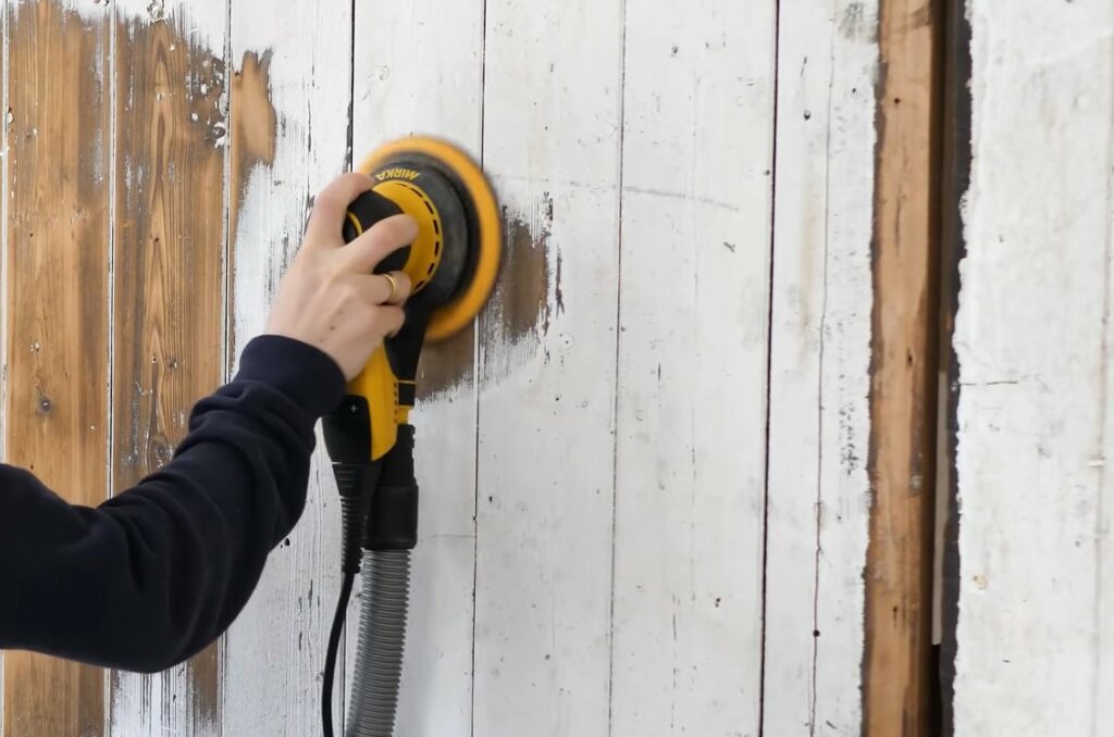 Poncer la peinture murale avec du papier de verre