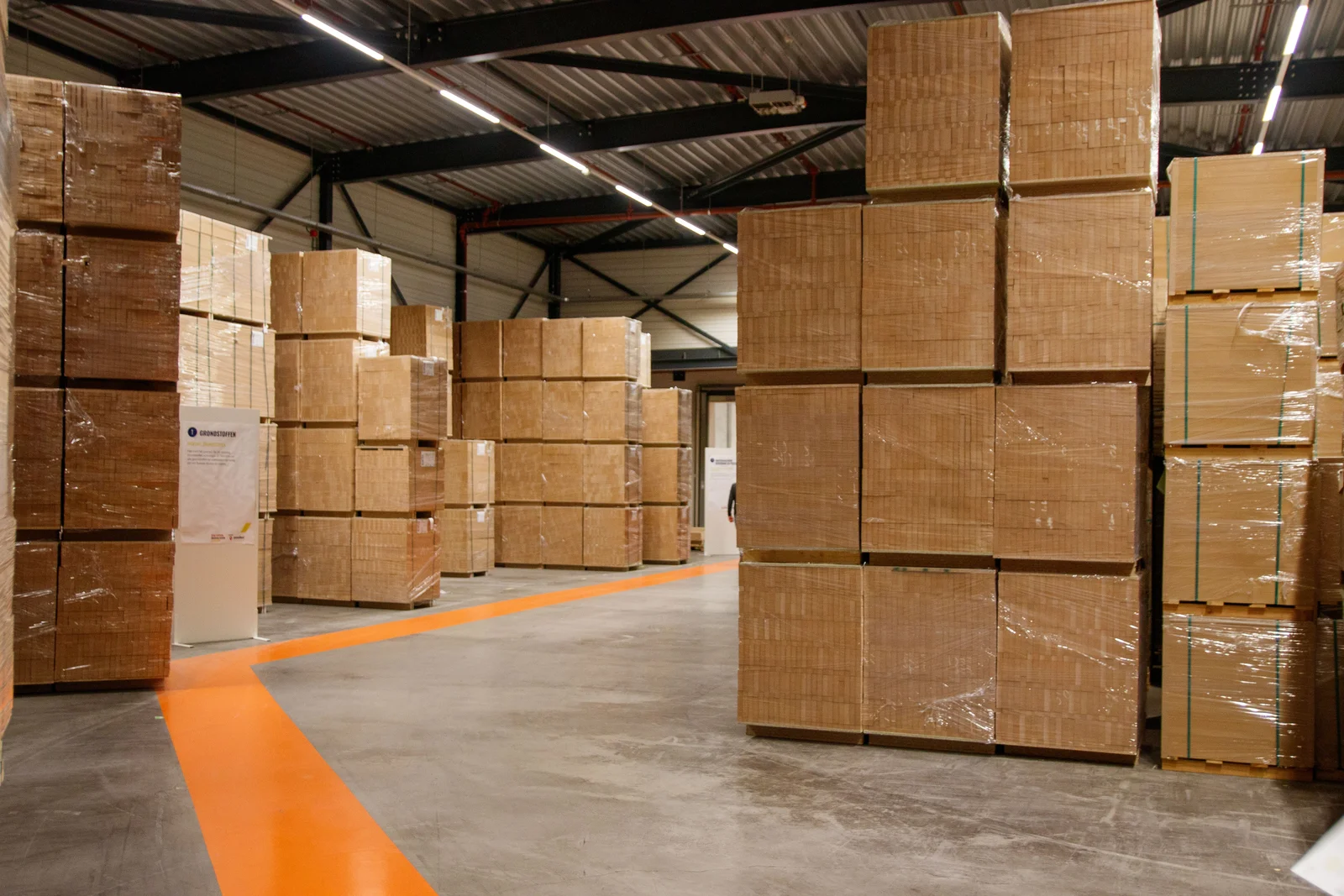 Palettes et cartons d'arrivage dans une allée de magasin de déstockage